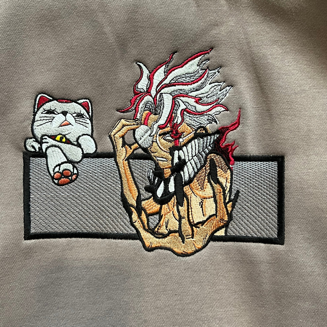 Hoodie brodé Okarun Kaito Global — gros plan du motif sur textile.