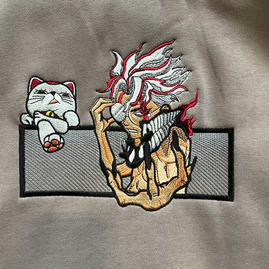 Hoodie brodé Okarun Kaito Global — gros plan du motif sur textile.