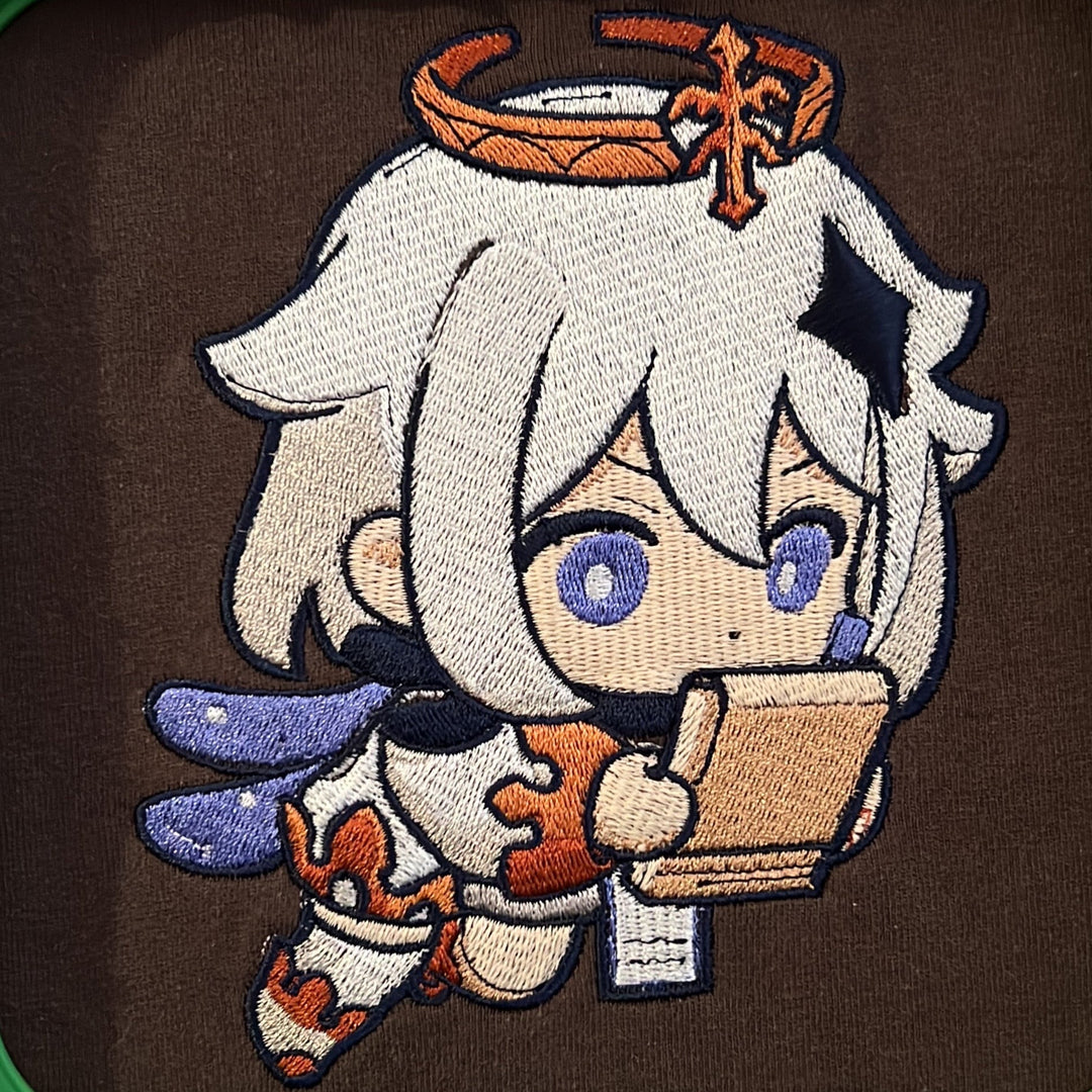 Hoodie brodé Paimon Kaito Global — gros plan du motif sur textile.