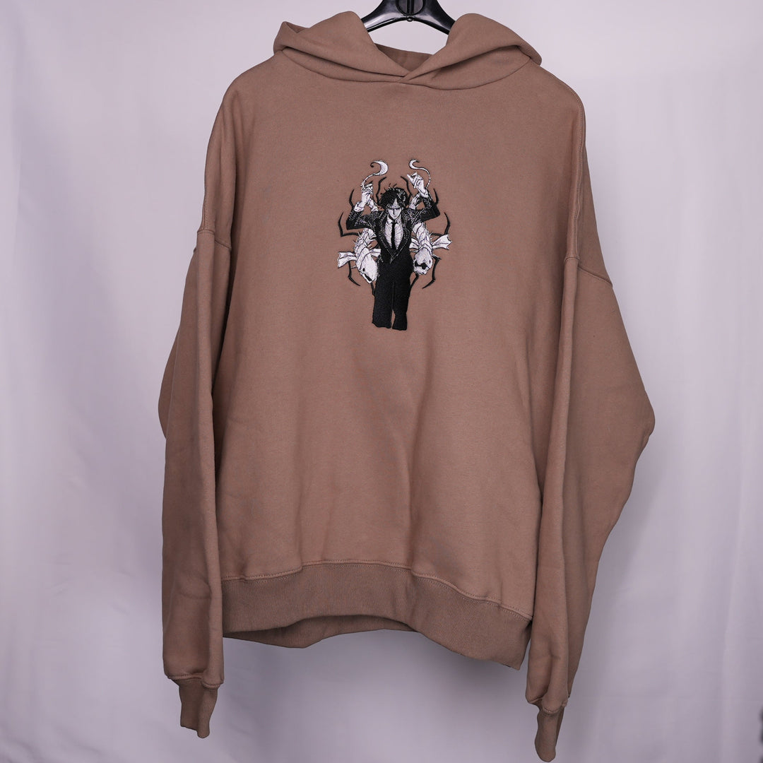 Hoodie brodé The False Prophet Kaito Global — gros plan du motif sur textile.